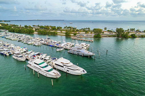 Luxury yacht boat docked at private mooring in tropical sea resort in Miami, USA.