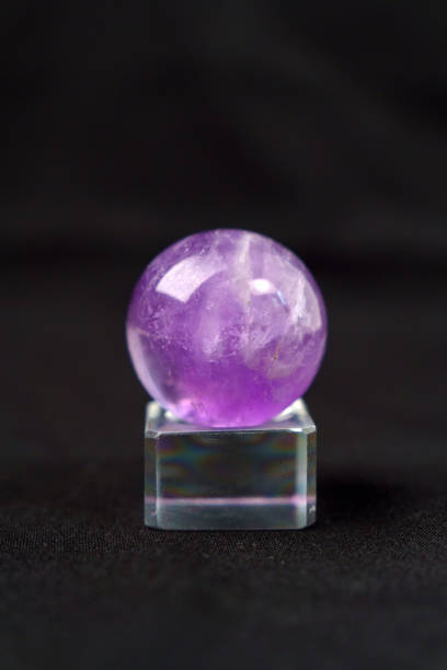 istock Natural mineral gemstone Amethyst gemstone on black background close up. Selective focus. Vertical photo 1413536371