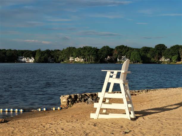Boats, canoes, sailboats and paddleboards on a lake in summer.