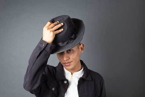 young male model putting on fedora hat