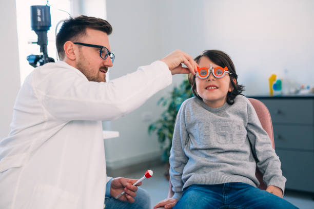 istock boy checking his eyesight in optic clinic 1413541581