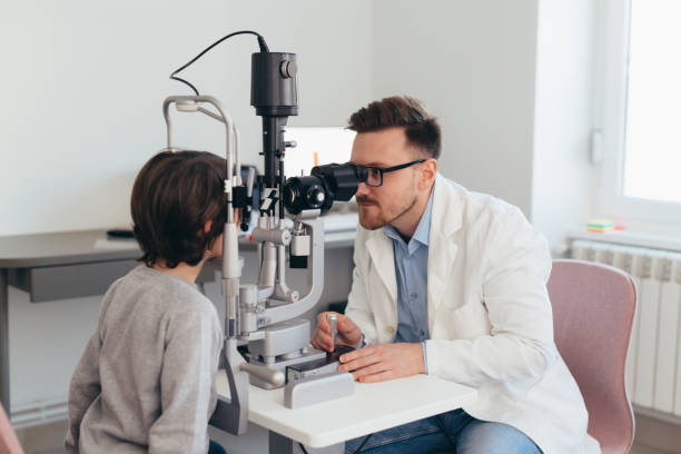 istock boy checking his eyesight in optic clinic 1413541582