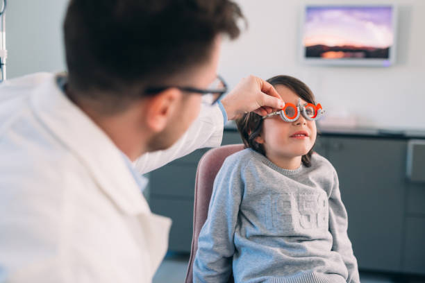 istock boy checking his eyesight in optic clinic 1413541585