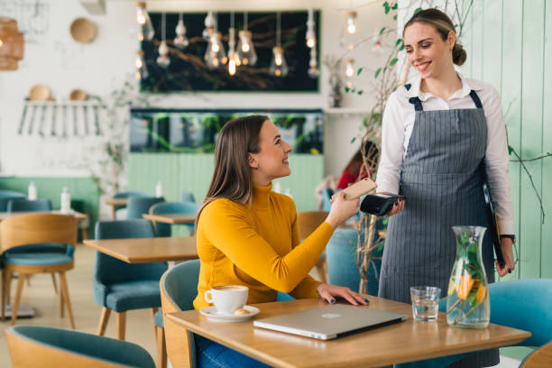 woma in restaurant woman paying c contactless with smartphone in cafe mobile payment stock pictures, royalty-free photos & images