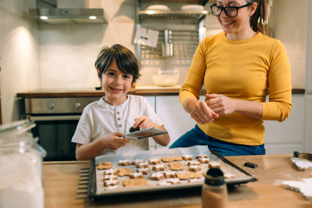 istock boy with her mother preparing cookies 1413541693