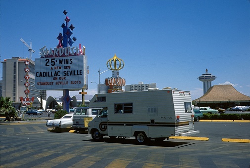 Las Vegas, Nevada, USA, 1975. Caravan in a Las Vegas parking lot. Also: buildings and a billboard.