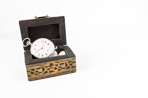 Vintage style pocket watch in wooden treasure box isolate on white background, valuable time