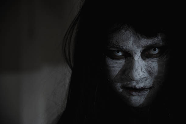 Close up face of horror woman ghost cruel, Asian woman ghost or zombie horror creepy scary close up she face and hair covering the face her eye looking to camera at night, Halloween day concept, in dark tone scary bride stock pictures, royalty-free photos & images