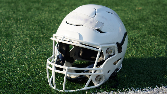 White football helmet on a turf field.