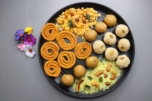 Indian festival food - Diwali Special sweet and salty snacks such as, Chakli, rava laddu, besan ladu, poha chivda, and corn mixture, Namkeen snacks. Diwali Faral from Maharashtra, India.