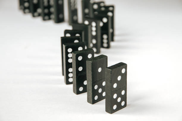 istock Black dominoes chain on white table background 1413550935