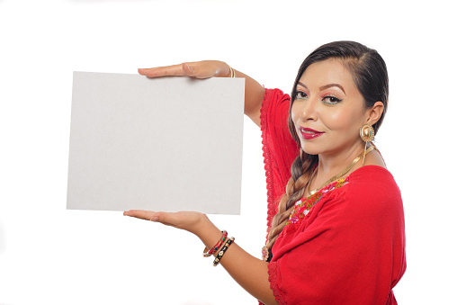 Mexican woman holding a blank poster. Portrait of Mexican woman in traditional dress holding a blank poster. White background.