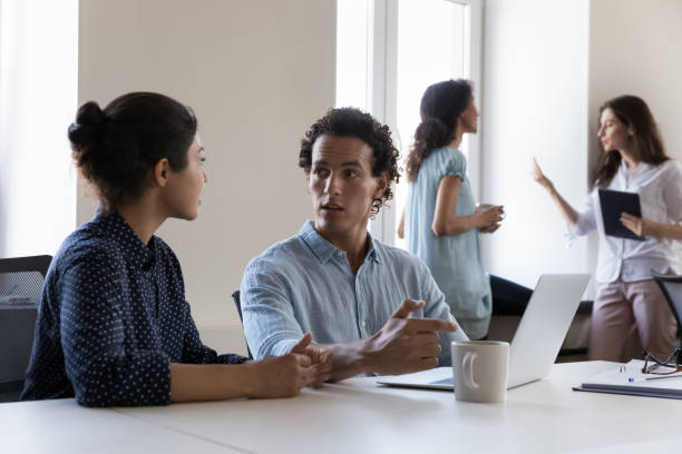 istock Multi ethnic millennial coworkers sit at desk discuss new project 1413551882