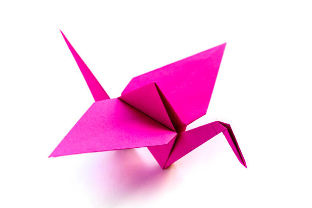 istock Pink paper crane origami isolated on a white background 1413551931