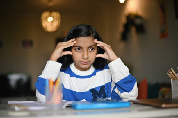 istock Girl sitting with her hands on head while studying 1413552650