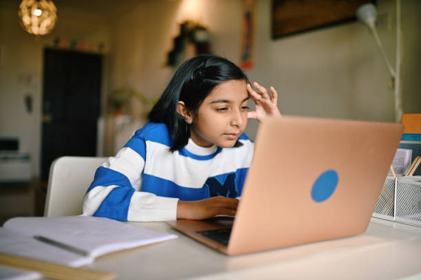 Girl using the laptop and looking at it with strained eyes