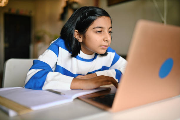 Girl using a laptop and looking at it with strained eyes