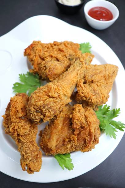 istock Fresh, hot, crispy deep fried chicken served on a white plate with tomato ketchup and mayonnaise. Chicken snack, hot fried chicken wings. Fast food over moody dark black background with copy space. 1413553202