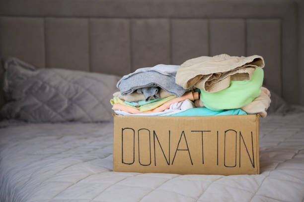 istock Donation box with clothes on the bed. 1413555333