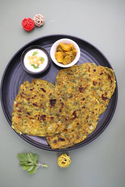 istock A Food called Methi paratha or Methi thepla is an Indian breakfast dish served with curd boondi raita and capsicum sabzi. Masala Fenugreek roti with copy space. 1413556592