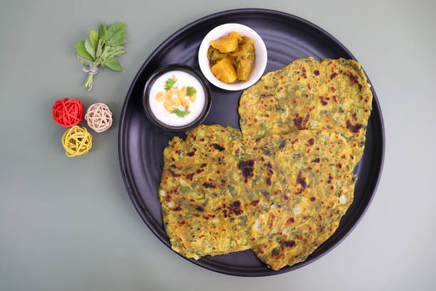 istock A Food called Methi paratha or Methi thepla is an Indian breakfast dish served with curd boondi raita and capsicum sabzi. Masala Fenugreek roti with copy space. 1413556596