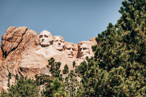 Mount Rushmore with American flag background and flying bald eagle in Black Hills, South Dakota, U.S.A.
