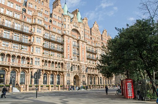 London, UK - March 21, 2022: View across a corner of Russell Square looking at the facade of the Kimpton Fitzroy Hotel, formerly the Hotel Russell, in Bloomsbury, London on a sunny spring afternoon.