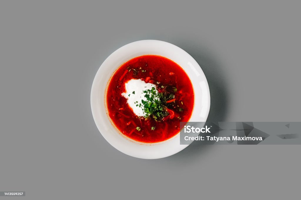 Hodgepodge soup in a white plate on gray. Hodgepodge soup in a white plate on gray solid background. Top view. Appetizer Stock Photo