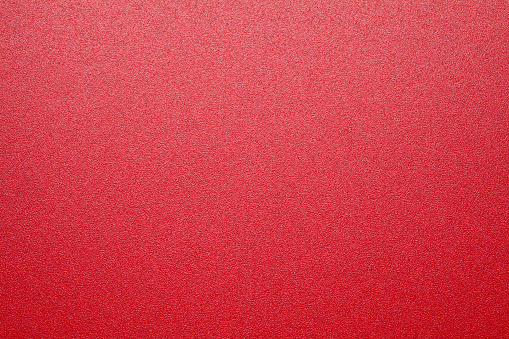 Red plastic material texture background. Close-up.