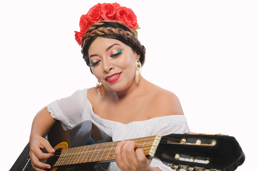 Mexican woman made up with Mexican flag colors wearing white dress. Mexican woman with guitar on white background.