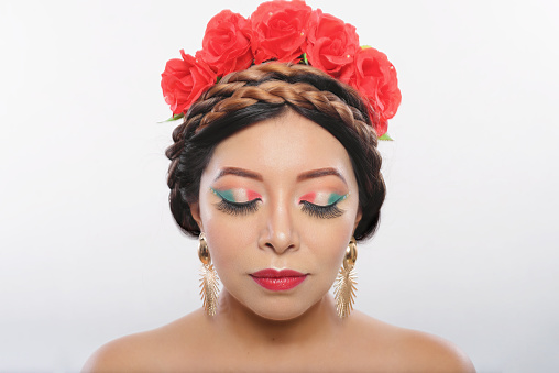 Mexican woman made up with the colors of the Mexican flag. Portrait of woman with closed eyes showing her makeup with the colors of the flag of Mexico.