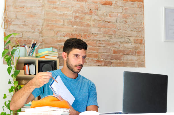 istock handsome student teaches his homework in a video call. back to school concept 1413561726