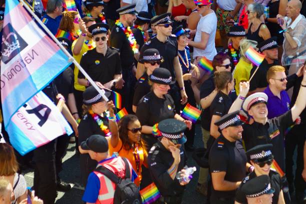 The police float mixed with participants holding up ACAB and No police in the parade posters in the parade at Brighton Pride 2022 Captured on Preston Rd near Preston Park in Brighton on Brighton Pride 6th August 2022. Brighton and Hove Pride is an annual LGBT pride event held in the city of Brighton and Hove, England, organised by Brighton Pride, a community interest company who promote equality and diversity, and advance education to eliminate discrimination against the lesbian, gay, bisexual and trans community. brighton england stock pictures, royalty-free photos & images