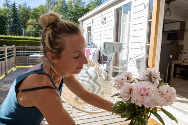 istock Woman setting flowers on a tale on her balcony 1413562386
