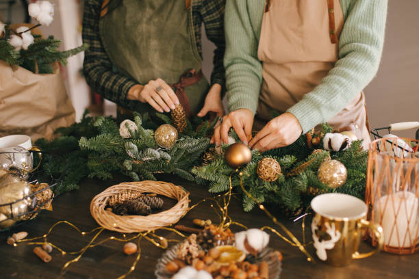 istock Two millennial women making Christmas wreath using pine branches and festive decorations. Small business 1413565226