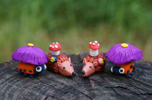 Two toy hedgehogs with mushrooms and two ladybugs.