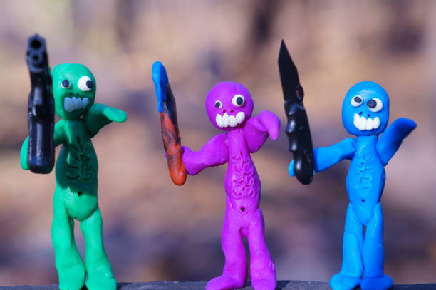 istock Figures of three zombies armed with a gun, a knife and an axe. 1413571359