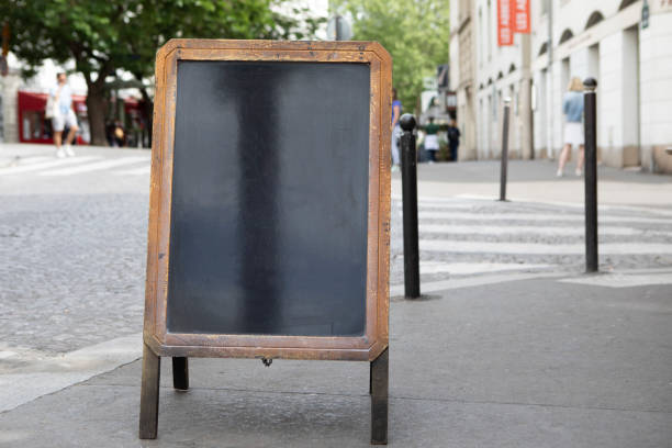 istock Plain chalkboard A-frame sign on a pavement outside a cafe in Paris 1413572294