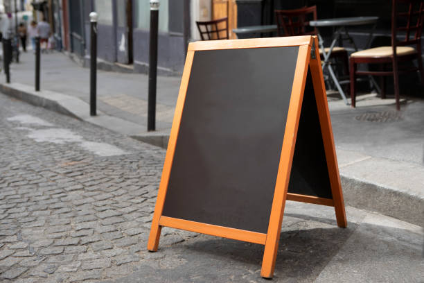 istock Plain chalkboard A-frame sign on a cobbled street outside a cafe in Paris 1413572303