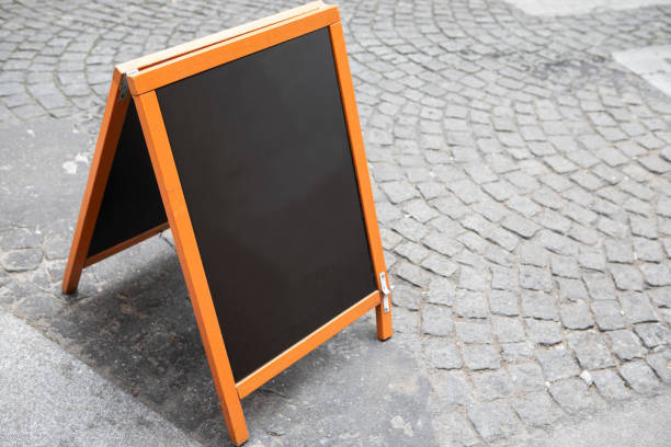 istock Plain chalkboard A-frame sign on a cobbled street outside a cafe in Paris 1413572319