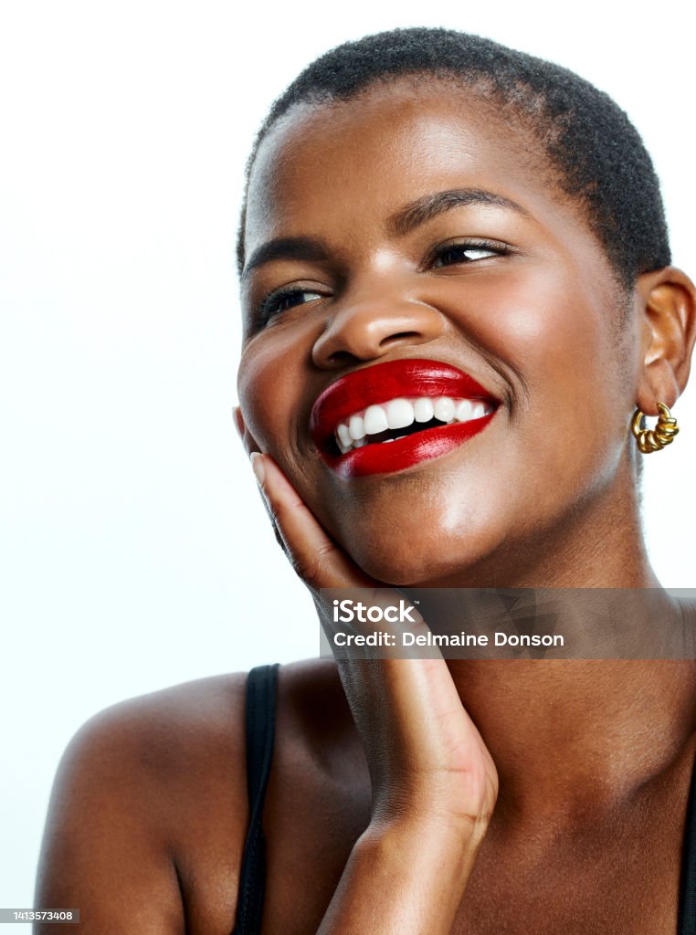 Beautiful, attractive woman wearing red lipstick standing against a white studio background with copyspace. Closeup face of an edgy female with a positive attitude, laughing and feeling cheerful African Ethnicity Stock Photo