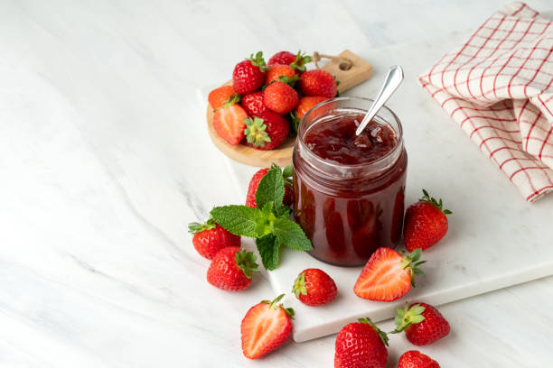 istock Bio Strawberry jam in glass jar at white table and Fresh Strawberries 1413577217