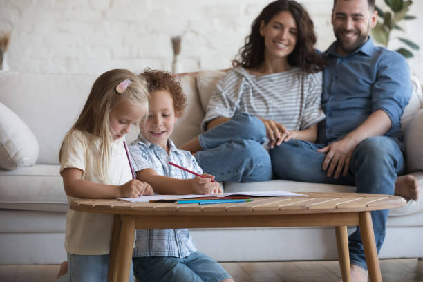 istock Happy satisfied young mother and father relaxing on sofa 1413577575