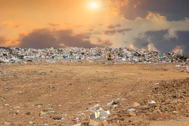 garbage dump pile in trash dump or landfill,poverty concept and environment.garbage dump pile and sunrise or sunset with copy space