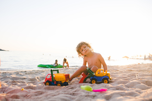 Little boy playing with sand on the beach