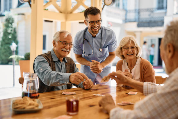 Happy seniors having fun while playing poker at nursing home.