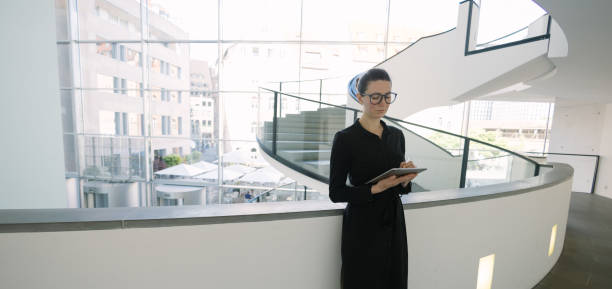 istock Business woman using tablet pc in minimalist office interior 1413581868