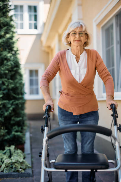 istock Senior woman using walker outdoors at nursing home and looking at camera. 1413582118