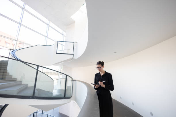istock Business woman using tablet pc in minimalist office interior 1413582150