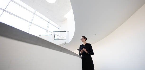 istock Business woman using tablet pc in minimalist office interior 1413582196
